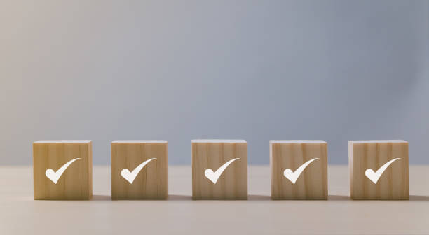 Checklist Survey and assessment concept, Checkmark icon on wooden blocks, gray background with copy space stock photo