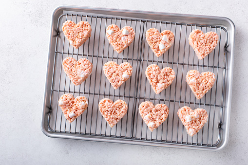 Heart shaped pink rice krispie treats for Valentines Day on a cooling rack