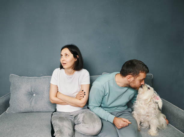 Man cuddling his dog do not pay attention to his wife stock photo