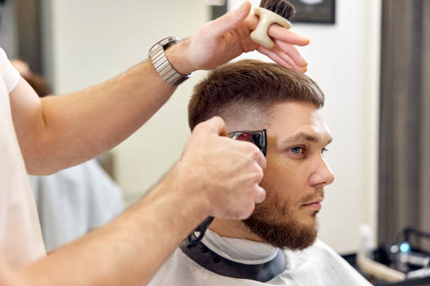 istock Barber trim hair with clipper on handsome bearded man 1458234522
