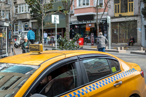 Istanbul,Turkey- January 20,2023: ellow taxi car with a checker in Cukurcuma area of Beyoglu district near Istiklal avenue on European side of Istanbul. It's considered the cultural center of the city.