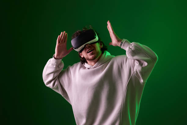 istock man in vr glasses and sweatshirt plays on blue background. 1458237256