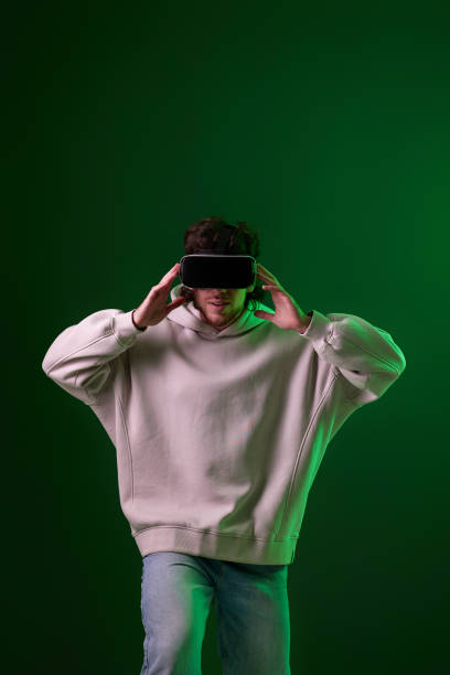 istock man in vr glasses and sweatshirt plays on blue background. 1458237263