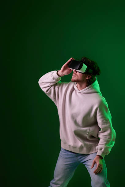 istock man in vr glasses and sweatshirt plays on blue background. 1458237271