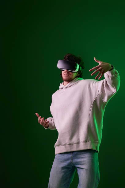 istock man in vr glasses and sweatshirt plays on blue background. 1458237288