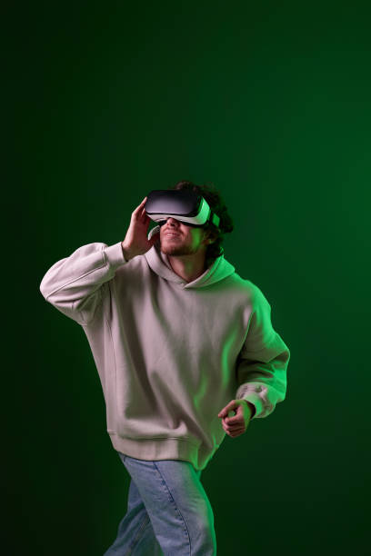 istock man in vr glasses and sweatshirt plays on blue background. 1458237296
