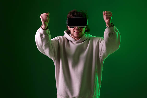 istock man in vr glasses and sweatshirt plays on blue background. 1458237309