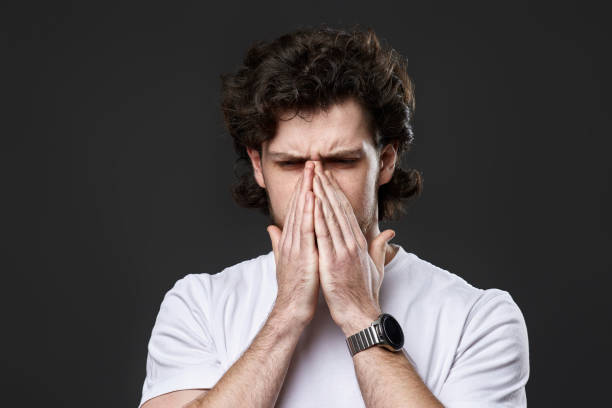 istock frustrated young man on dark gray background. sadness 1458237366