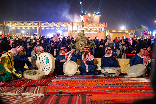 This photo has been taken in Riyadh, Saudi Arabia. In the photo appear a band who do traditional dance and music. this kind of dance exists mainly in the west of Saudi Arabia, Hejaz region.