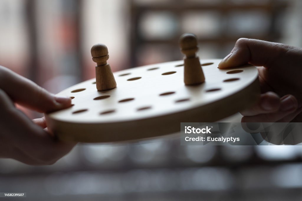 Wooden Memory Game in Child Hands Two children's hands hold a wooden memory game
Close shot. Window in background. 12-13 Years Stock Photo