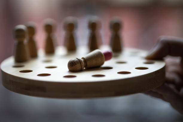 Wooden Memory Game in Child Hand. Close shot. Window in background.