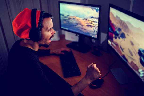 istock Young gamer is sitting at a computer, playing computer games 1458241960