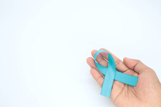 istock hand holding light blue ribbon on white background,November Pros 1458244603