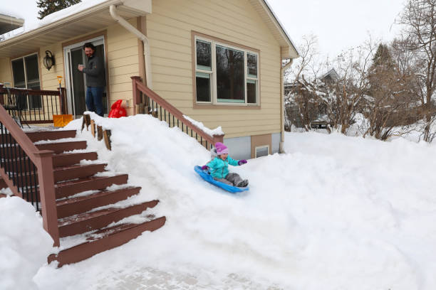 Cheerful father and daughter sledding