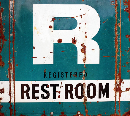 Old-fashioned sign advertising a roadside rest room.