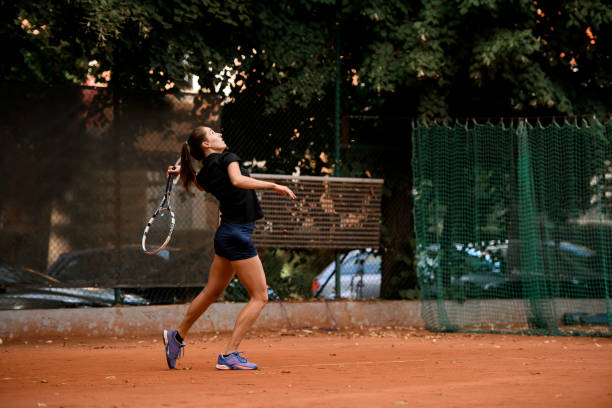 hermosa jugadora deportiva con raqueta de tenis jugando en la cancha de tenis al aire libre. - athlete flying tennis recreational pursuit fotografías e imágenes de stock