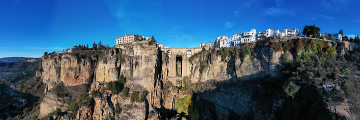 Rocky landscape of Ronda city with Puente Nuevo Bridge and buildings, Andalusia, Spain
