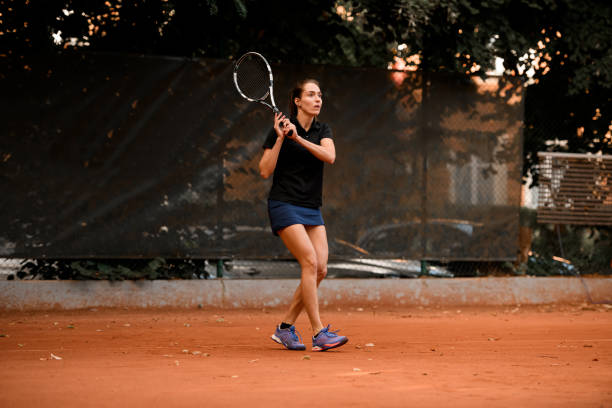 jugadora de tenis activa con raqueta lista para golpear una pelota de tenis. - athlete flying tennis recreational pursuit fotografías e imágenes de stock