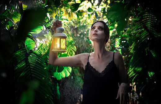 A woman with a lantern in the rainforest