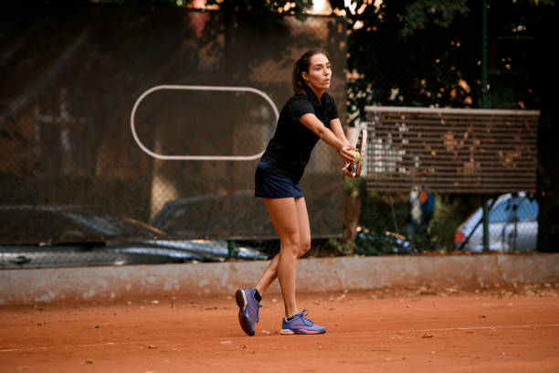 guapo tenista femenino sosteniendo pelota de tenis mientras se prepara para servir - athlete flying tennis recreational pursuit fotografías e imágenes de stock