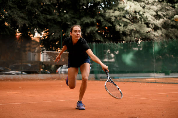 gran tiro en movimiento de tenista femenina con raqueta antes de golpear la pelota - athlete flying tennis recreational pursuit fotografías e imágenes de stock