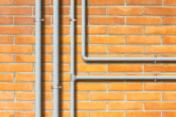 istock Water and gas galvanized metal pipeline in front a brick wall 1458257871