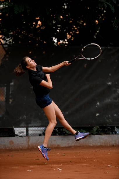 hermosa vista de la deportista activa jugadora de tenis con raqueta de tenis en la mano haciendo pitch - athlete flying tennis recreational pursuit fotografías e imágenes de stock