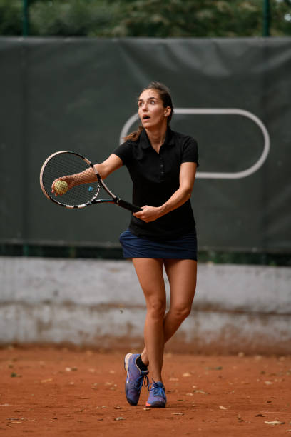 przystojna, atletyczna tenisistka z rakietą i piłką przygotowuje się do podania na początku gry - athlete flying tennis recreational pursuit zdjęcia i obrazy z banku zdjęć