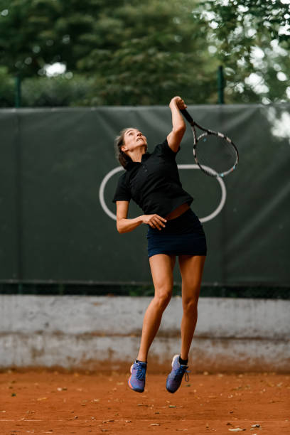 zobacz pewną siebie tenisistkę z rakietą gotową do uderzenia piłki tenisowej. - athlete flying tennis recreational pursuit zdjęcia i obrazy z banku zdjęć