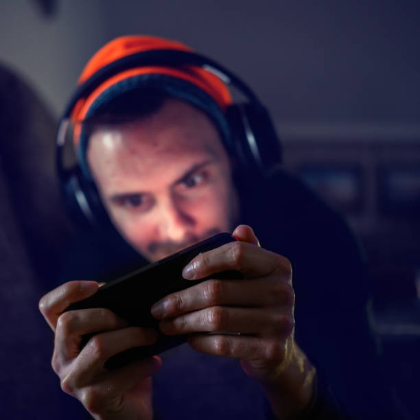 istock Young gamer plays action video game on mobile phone 1458262865