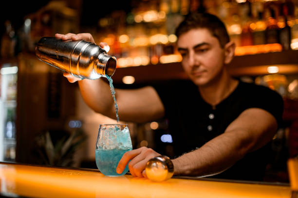 istock great view of glass with ice into which bartender pours blue cocktail from shaker 1458266034