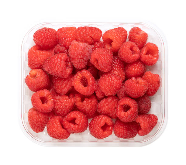 istock Whole fresh raspberries, ripe and red fruits, in a clear plastic punnet 1458266057