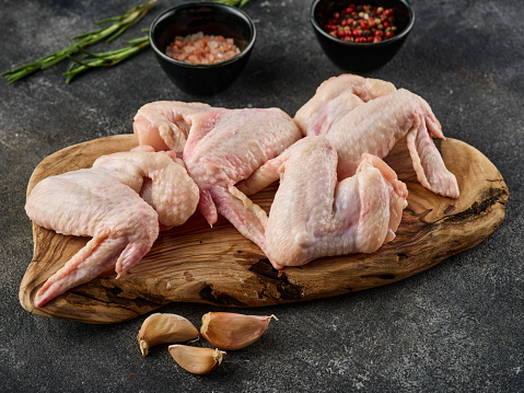 Raw chicken wings Poultry meat with spices, salt and pepper, on gray background