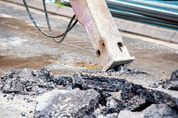 escavatore con martello pneumatico idraulico che rompe l'asfalto in preparazione per lavori di drenaggio ravvicinato e messa a fuoco selettiva - construction australia rebuilding street foto e immagini stock