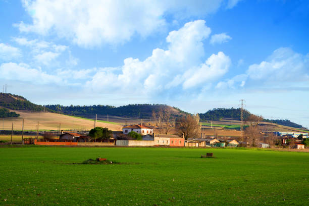 istock Beautiful landscape scenery with meadow and small buildings under blue sky 1458270955