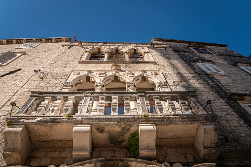 Looking up at ancient palace building facade in the Old City of Trogir, Croatia
