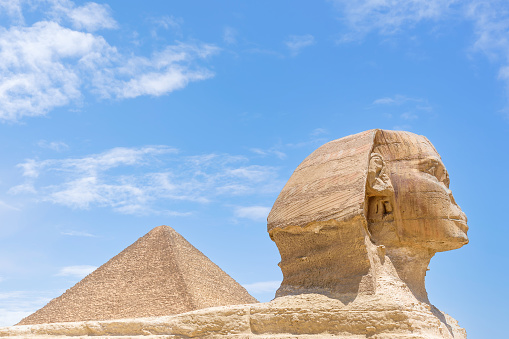 The Great Sphinx of Giza, Giza Necropolis, Egypt - July 27, 2022:  The Great Sphinx of Giza is a limestone statue of a reclining sphinx, a mythical creature with the head of a human, and the body of a lion. Facing directly from west to east, it stands on the Giza Plateau on the west bank of the Nile in Giza, Egypt. The face of the Sphinx appears to represent the pharaoh Khafre.\n\nThe original shape of the Sphinx was cut from the bedrock, and has since been restored with layers of limestone blocks. It measures 73 m (240 ft) long from paw to tail, 20 m (66 ft) high from the base to the top of the head and 19 m (62 ft) wide at its rear haunches.[4] Its nose was broken off for unknown reasons between the 3rd and 10th centuries AD.\n\nThe Sphinx is the oldest known monumental sculpture in Egypt and one of the most recognisable statues in the world. The archaeological evidence suggests that it was created by ancient Egyptians of the Old Kingdom during the reign of Khafre (c. 2558–2532 BC).