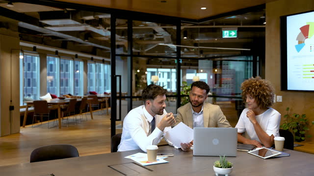 Three business people meeting and discussing a document in the office
