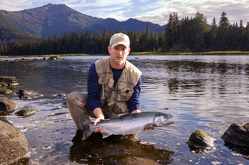 Portrait of a male fisherman proudly showing the fish he caught