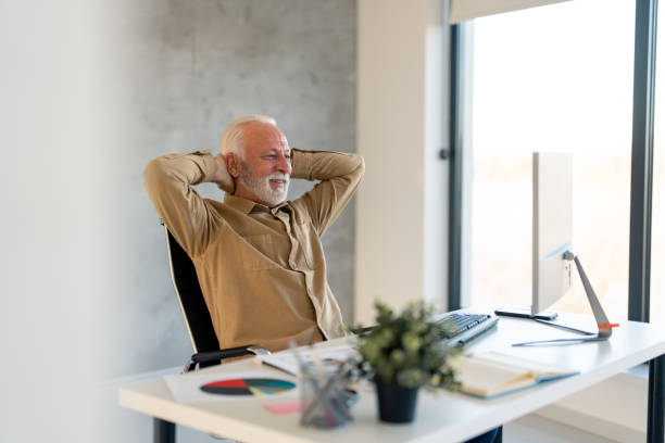 istock Satisfied older senior businessman resting after successful work sitting with hands behind his head 1458289710