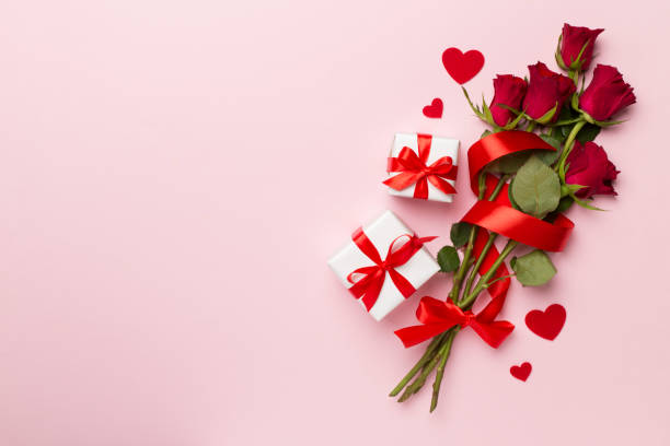 istock Valentines day gift box with red roses on color background, top view 1458291161
