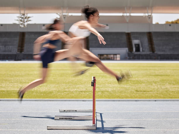 atletismo femenino, deportivo y de vallas corriendo para hacer ejercicio, entrenamiento o entrenamiento en la pista del estadio al aire libre. mujeres atletas de fitness en el deporte competitivo saltando obstáculos para cardio saludable al aire libre - hurdling hurdle running track event fotografías e imágenes de stock