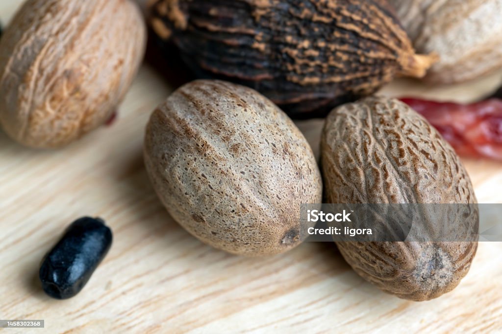 A whole nutmeg fruit on the kitchen table A whole nutmeg fruit on the kitchen table, using the nutmeg spice during cooking Aromatherapy Stock Photo