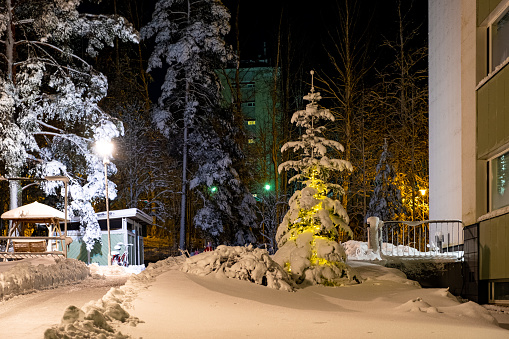 Finland Lahti city at night. Snow-covered city courtyard with a Christmas tree and electric lighting.