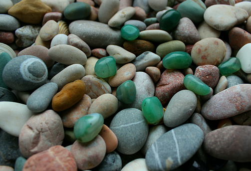 Green Semi-Precious Stones On A Colored Pebbles With Quartz Veins Texture Backgrounds