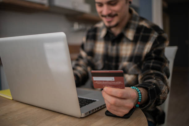 istock Man using his credit card to shop online 1458306259