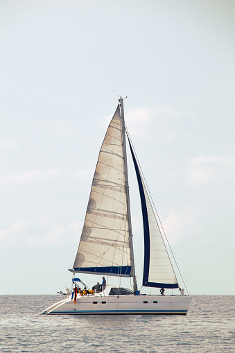 Sailboat in profile with some people on board and a Germany flag on the side