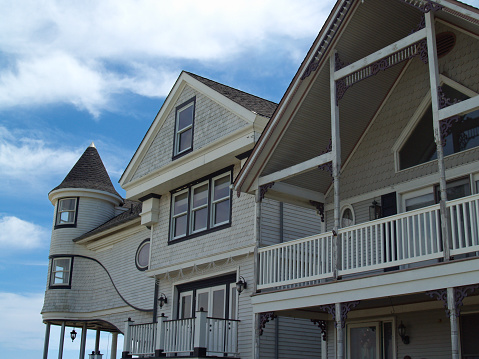 Beautiful Victorian Revival vacation homes are depicted in the historical coastal town of Ocean Grove, New Jersey (part of series of 3 different views of home on left). Ocean Grove, a small town beside Asbury Park, was founded by Methodists in late 1800s. Image is in horizontal orientation and was photographed with a DSLR on a clear day.