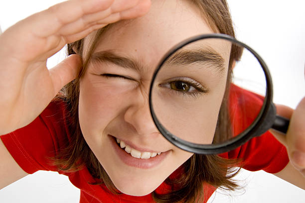 istock Young woman looking through a magnifying glass smiling 145831615