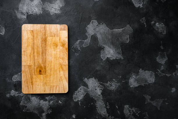 istock Pine wooden cutting board, on black dark stone table background, top view flat lay , with copy space for text or your product 1458316855
